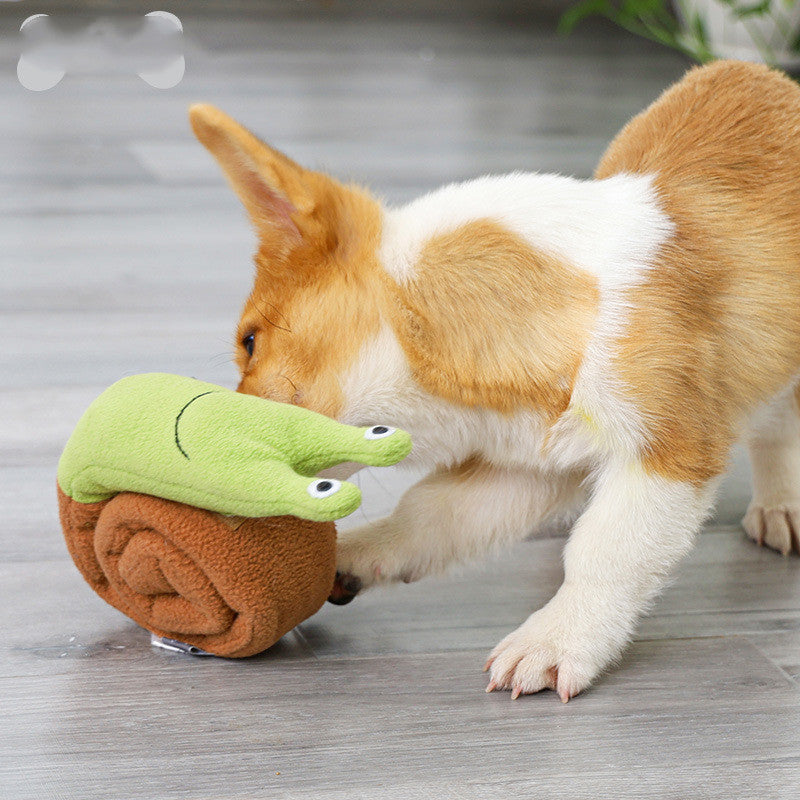 Small dog nosing a fleece snuffle snail puzzle toy on the floor to find treats