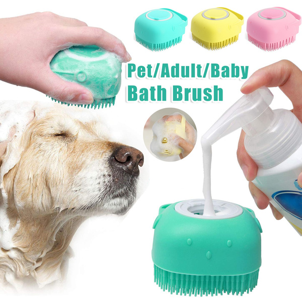 Hand using a mint silicone dog bath brush on a golden retriever while adding shampoo