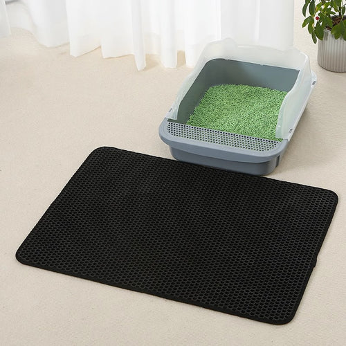 Black double-layer cat litter trapping mat in front of a litter box